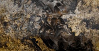 Dark water swirling between rocks in a shallow stream